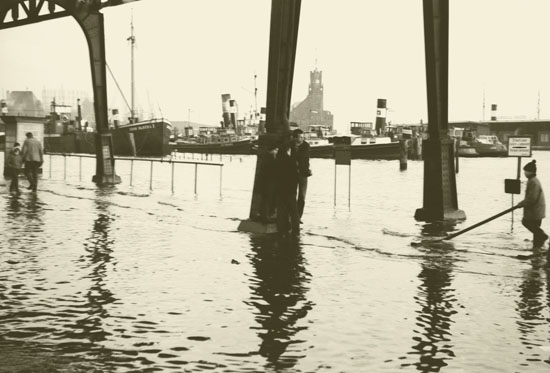Überschwemmung in Hamburg an den Vorsetzen am 17.02.1962. Im Vordergrund sind zu sehen die Stützpfeiler des Hochbahn-Viaduktes, im Hintergrund sieht man das Gebäude Kehrwiederspitze