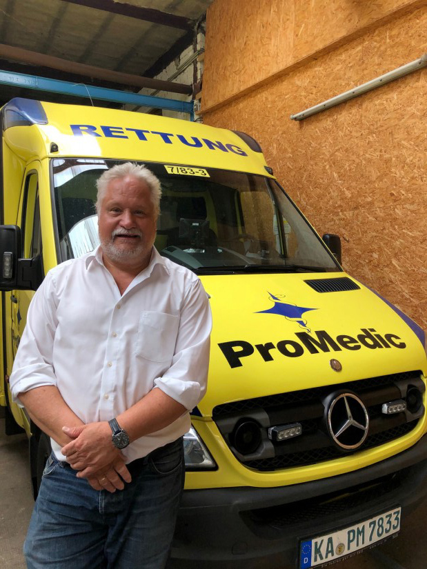 Andreas Wolf vor einem modernen Rettungswagen der ProMedic Rettungsdienst gGmbH (August 2020)